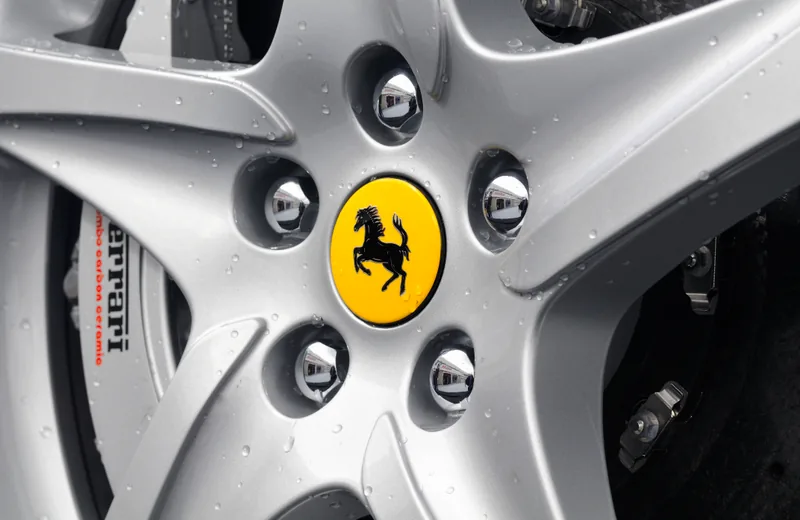 Close view through a Ferrari wheel showing the face and space behind the spokes